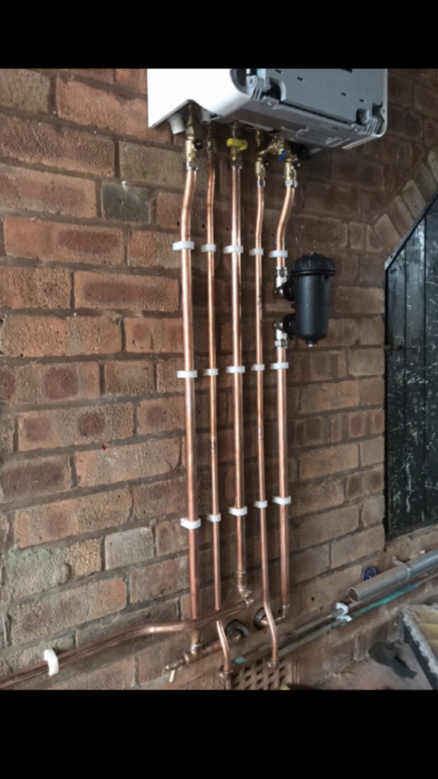 Five copper drops under a boiler, clipped in line with isolation valves and a magnetic filter